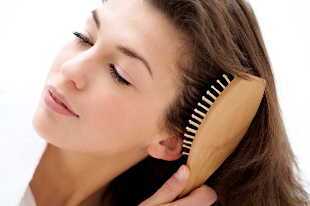 Portrait of a young woman brushing her hair