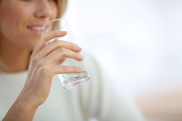 Closeup on glass of water held by woman's hand