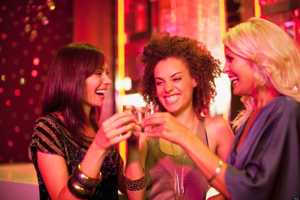 Friends toasting shot glasses in nightclub. Image shot 2010. Exact date unknown.