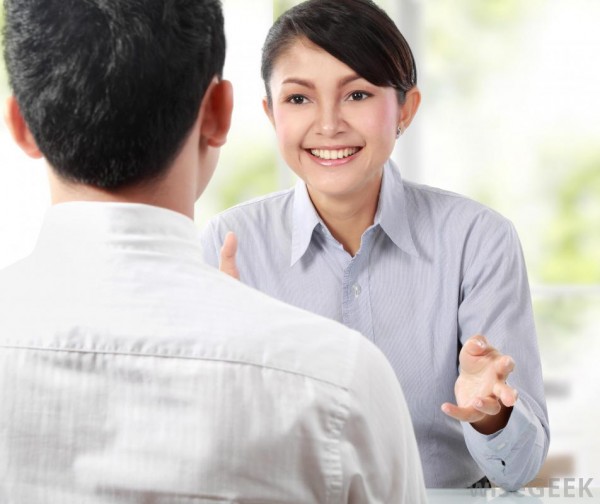 dark-haired-woman-smiling-at-man-in-white-shirt-across-from-her