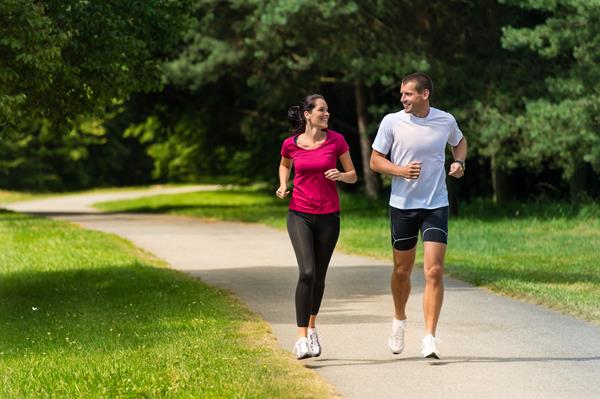 Cheerful Caucasian couple friends running in park