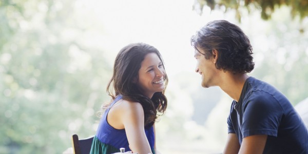 Smiling couple having tea outdoors