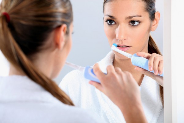 Woman with an electric toothbrush