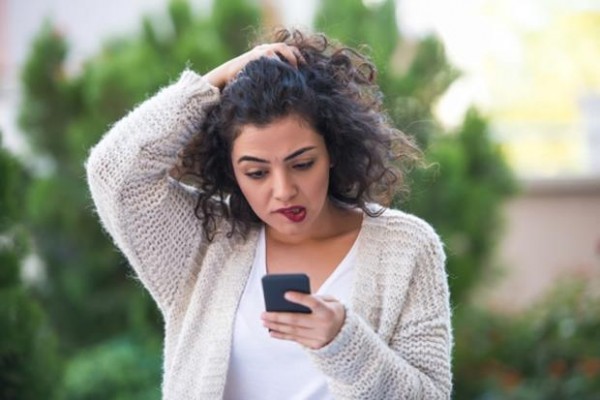 Woman receiving bad news on smartphone. Image taken with NIKON D800 camera system and developed from camera RAW.