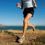 Woman running along coastline,  California,  USA