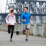 A man and woman running in the city.