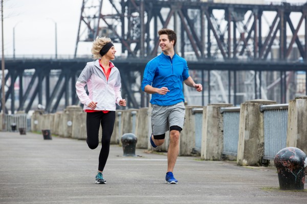 A man and woman running in the city.