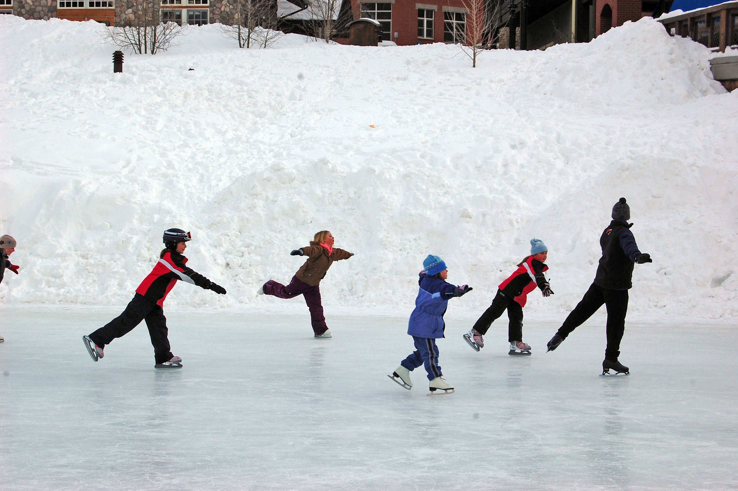 Катания развлечения. Дети катаются на льду. Зимние забавы. Зимние развлечения. Дети на коньках.